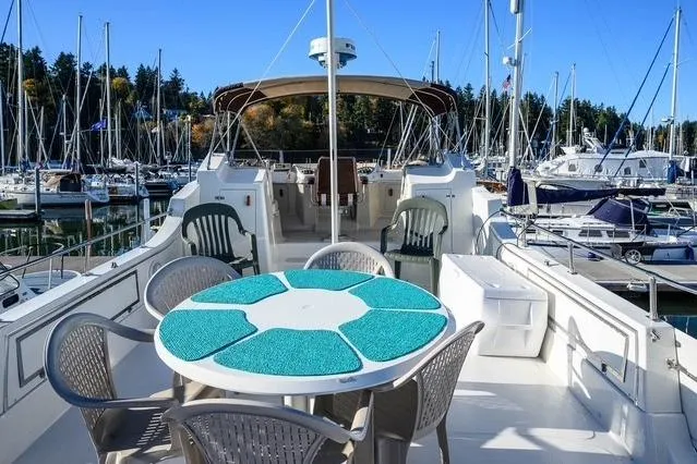 Slide: The Image of 1984 Uniflite YACHTHOME with outdoor seating, docked in a marina. - 8