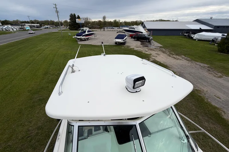 Slide: The Image of 2006 Pursuit 2570 Offshore boat roof with spotlight, parked near other boats. - 14