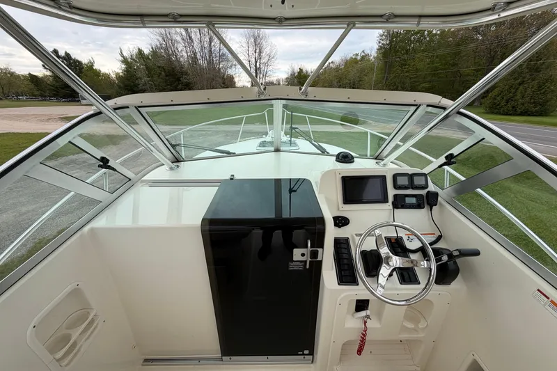 Slide: The Image of 2006 Pursuit 2570 Offshore boat cockpit with steering wheel and navigation equipment. - 17