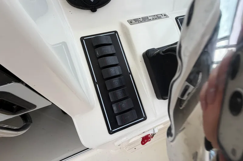 Slide: The Image of Control panel of a 2006 Pursuit 2570 Offshore boat with switches and branding. - 19