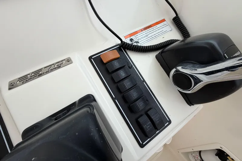 Slide: The Image of Control panel of a 2006 Pursuit 2570 Offshore boat with switches and throttle. - 20