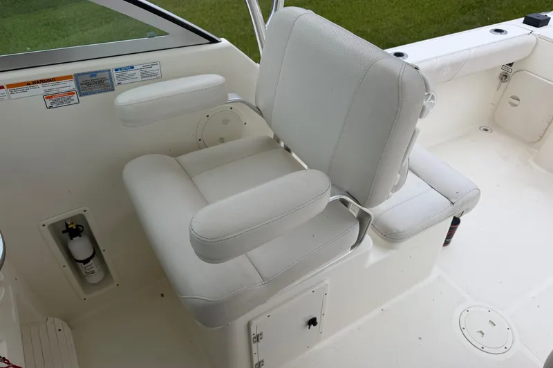 Slide: The Image of White captain's chair on 2006 Pursuit 2570 Offshore boat, featuring armrests and clean upholstery. - 21