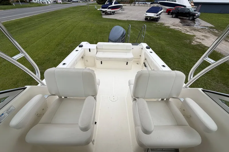 Slide: The Image of 2006 Pursuit 2570 Offshore boat interior with white seating and open deck. - 23