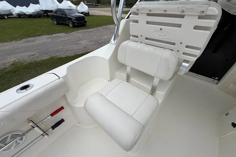 Slide: The Image of 2006 Pursuit 2570 Offshore boat seat with white upholstery and storage compartments. - 25