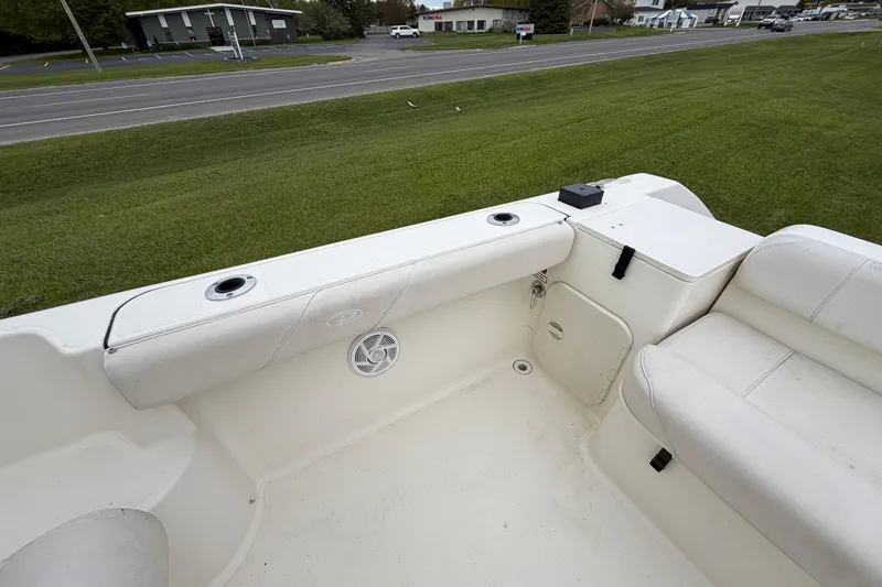 Slide: The Image of 2006 Pursuit 2570 Offshore boat interior with white seating and storage compartments. - 29