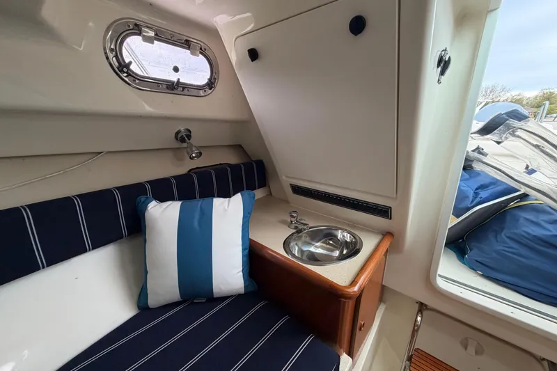 Slide: The Image of Interior of 2006 Pursuit 2570 Offshore boat with striped seating and small sink. - 32