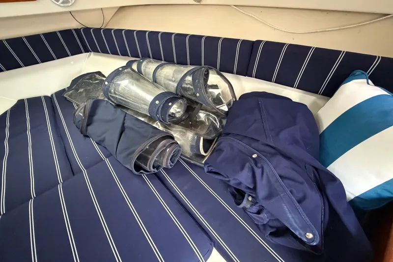 Slide: The Image of 2006 Pursuit 2570 Offshore boat interior with striped cushions and rolled-up canvas covers. - 35