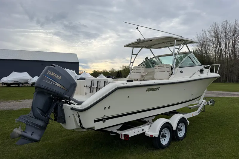 Slide: The Image of 2006 Pursuit 2570 Offshore boat with Yamaha engine on trailer, parked on grass. - 6