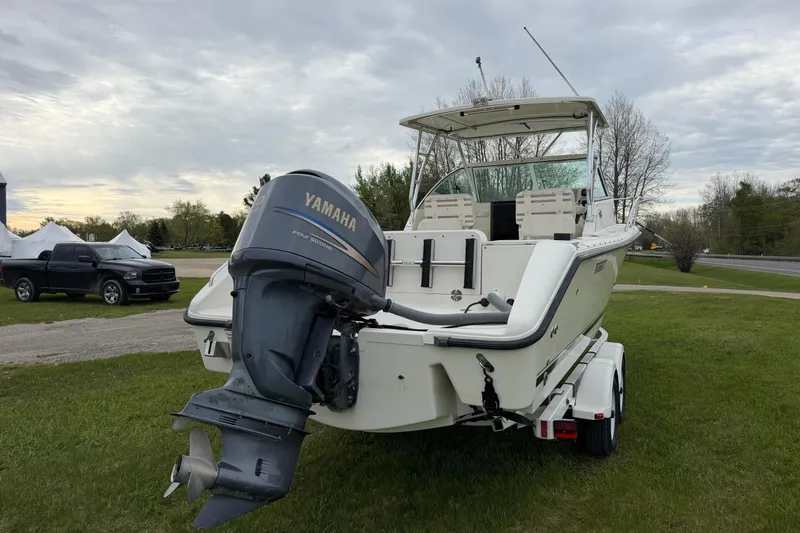 Slide: The Image of 2006 Pursuit 2570 Offshore boat with Yamaha outboard motor on trailer, parked on grass. - 7