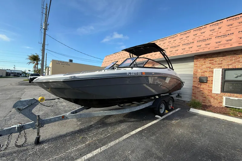 The Image of 2020 Yamaha AR230 boat on trailer in parking lot, sunny day. - 1