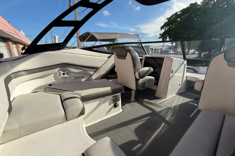 Slide: The Image of 2020 Yamaha Boats AR230 interior with seating and steering console under clear blue sky. - 10