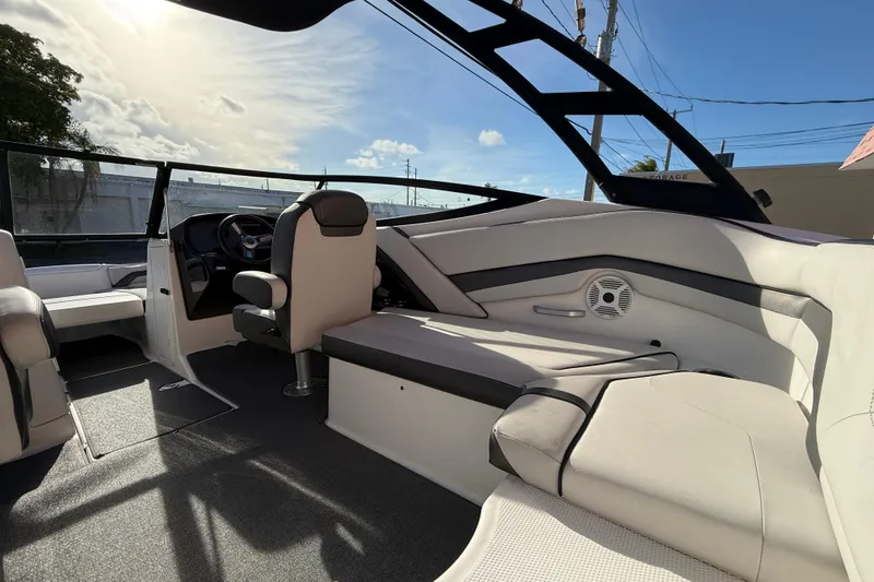 Slide: The Image of 2020 Yamaha Boats AR230 interior with modern seating and steering wheel under sunny skies. - 11
