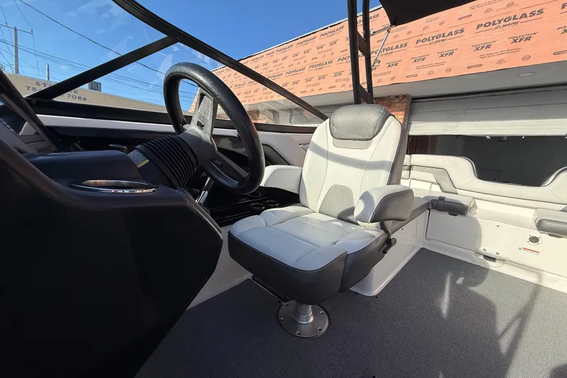 Slide: The Image of Interior of a 2020 Yamaha Boats AR230, featuring a sleek captain's chair and steering wheel. - 14