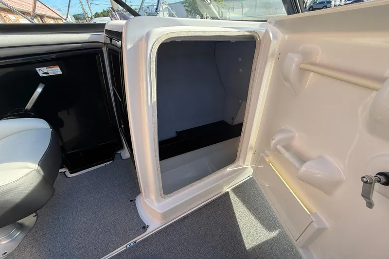 Slide: The Image of 2020 Yamaha Boats AR230 interior storage compartment with open door, showcasing spacious design. - 21