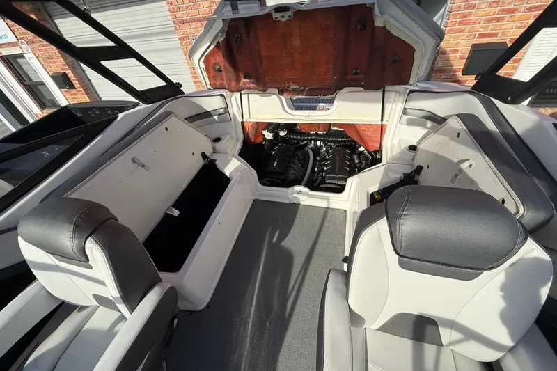 Slide: The Image of 2020 Yamaha AR230 boat interior with open engine compartment, showcasing seating and storage. - 22