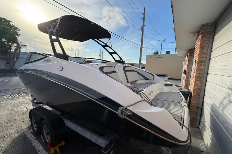 Slide: The Image of 2020 Yamaha Boats AR230 on trailer, parked outdoors, with a sleek black and white design. - 3