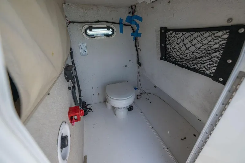 Slide: The Image of 2007 ProKat 2860 Center Console boat interior with toilet and storage net. - 15