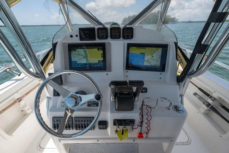Slide: The Image of 2007 ProKat 2860 Center Console boat dashboard with navigation screens and steering wheel. - 60