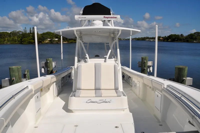 Slide: The Image of 2011 Yellowfin 39 Offshore boat docked by a serene lake under a clear sky. - 13