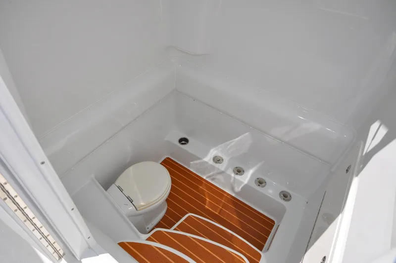 Slide: The Image of 2011 Yellowfin 39 Offshore boat bathroom with wooden flooring and white toilet. - 17