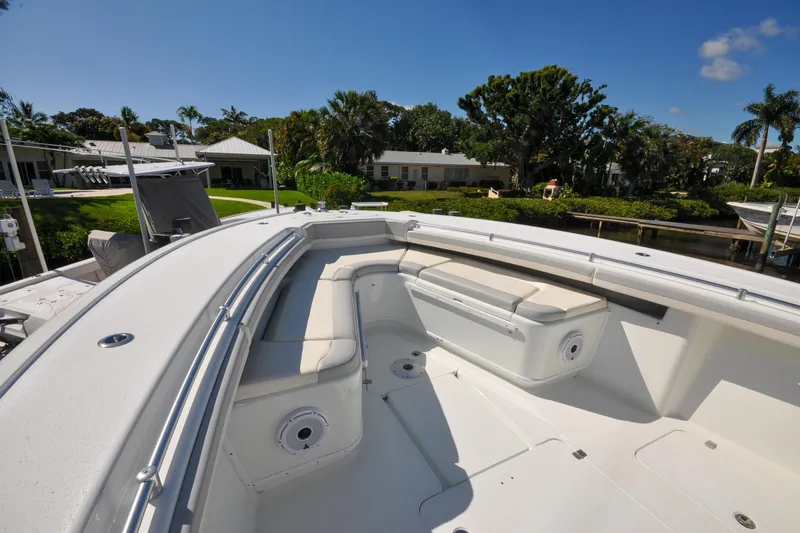 Slide: The Image of 2011 Yellowfin 39 Offshore boat with spacious seating and sleek design, docked near lush greenery. - 18