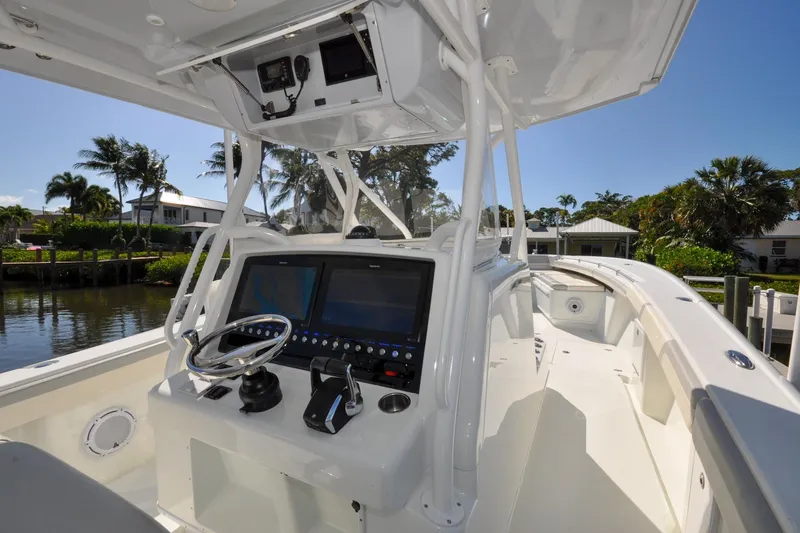 Slide: The Image of 2011 Yellowfin 39 Offshore boat cockpit with modern navigation system and steering wheel. - 2
