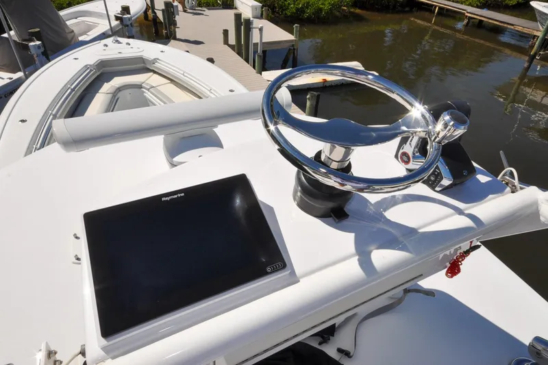Slide: The Image of 2011 Yellowfin 39 Offshore boat helm with Raymarine display and chrome steering wheel. - 23