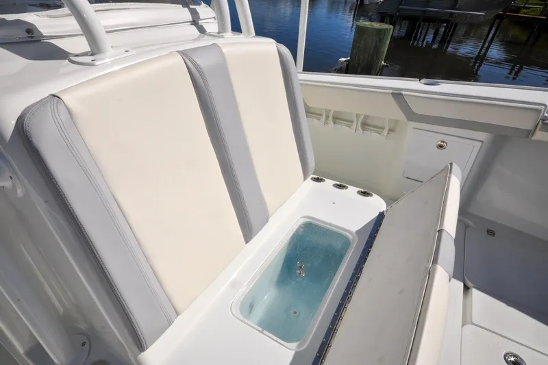 Slide: The Image of 2011 Yellowfin 39 Offshore boat interior with cushioned seating and built-in storage. - 27