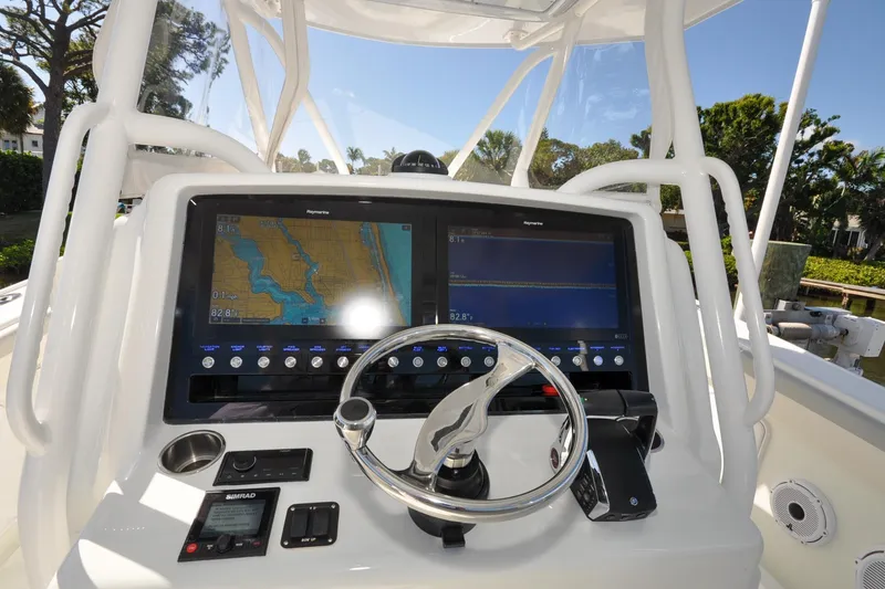Slide: The Image of 2011 Yellowfin 39 Offshore boat dashboard with navigation screens and steering wheel. - 3