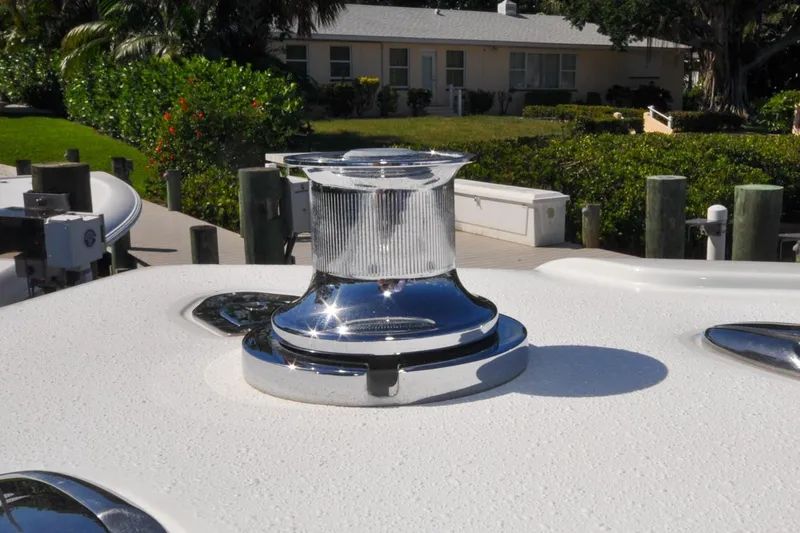Slide: The Image of Chrome winch on 2011 Yellowfin 39 Offshore boat deck, docked near greenery. - 34