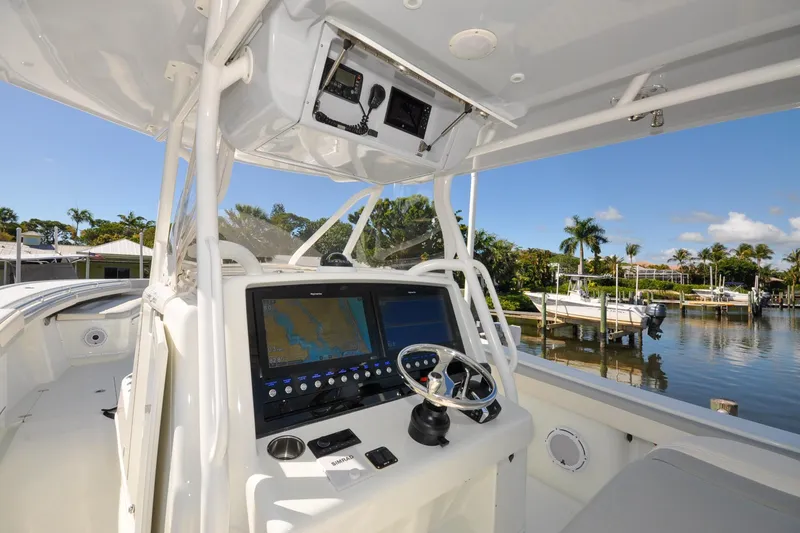 Slide: The Image of 2011 Yellowfin 39 Offshore boat cockpit with navigation system, steering wheel, and waterfront view. - 4