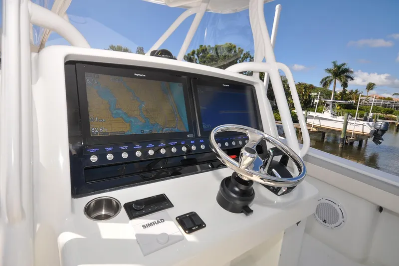 Slide: The Image of 2011 Yellowfin 39 Offshore boat helm with navigation screens and steering wheel. - 5
