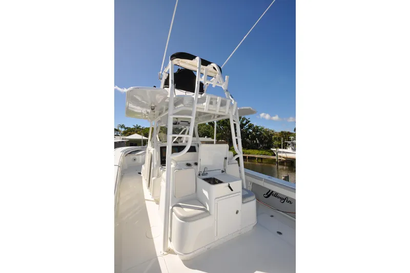 Slide: The Image of 2011 Yellowfin 39 Offshore boat with tower and seating, docked under clear blue sky. - 8