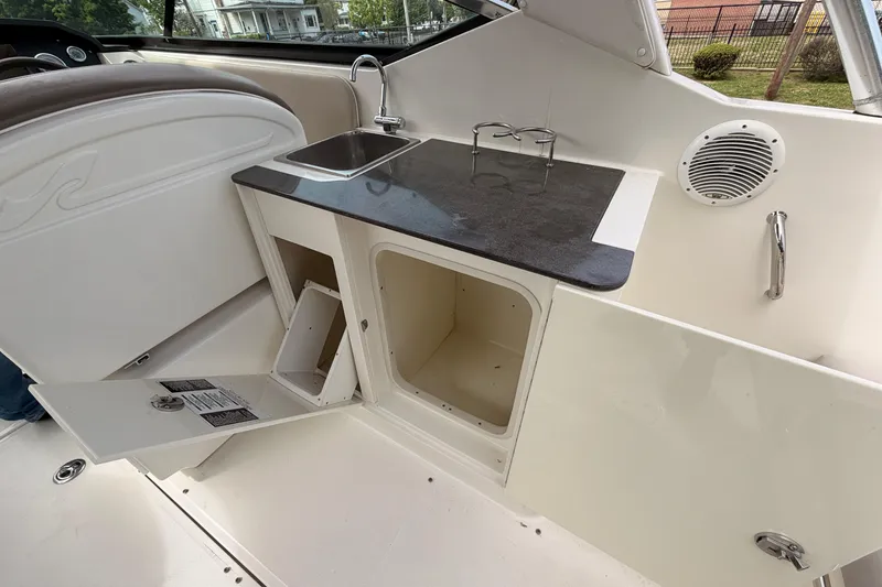 Slide: The Image of Interior of a 2011 Sea Ray 300 SLX boat featuring a compact kitchenette with sink. - 12