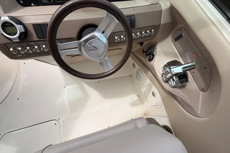 Slide: The Image of Steering wheel and controls of a 2011 Sea Ray 300 SLX boat cockpit. - 15