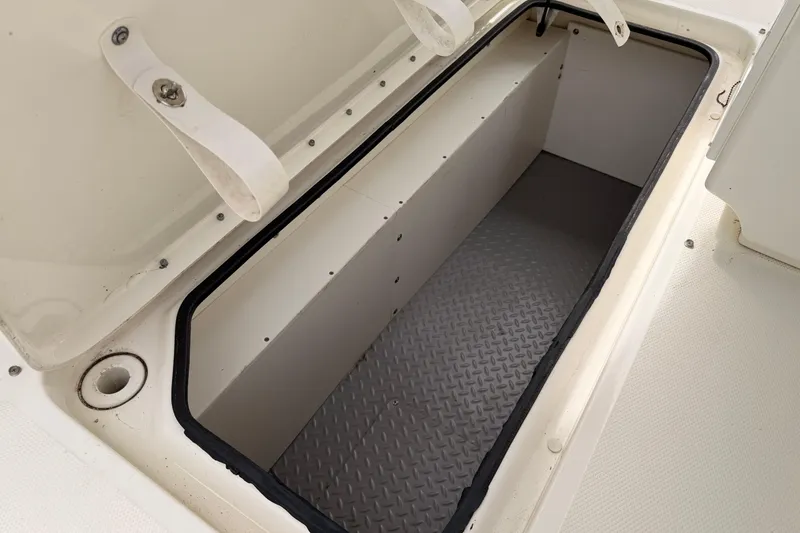 Slide: The Image of Open storage compartment on a 2011 Sea Ray 300 SLX boat, featuring a textured floor. - 25
