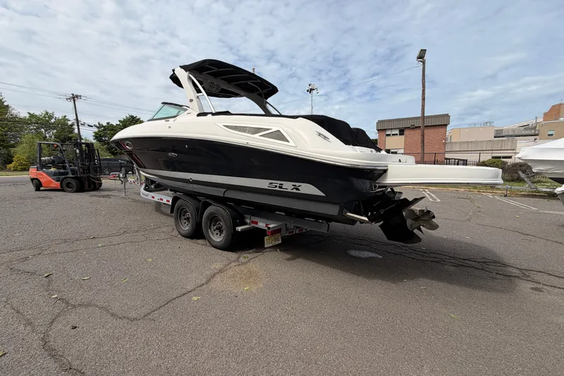 Slide: The Image of 2011 Sea Ray 300 SLX boat on trailer in parking lot, overcast sky. - 4