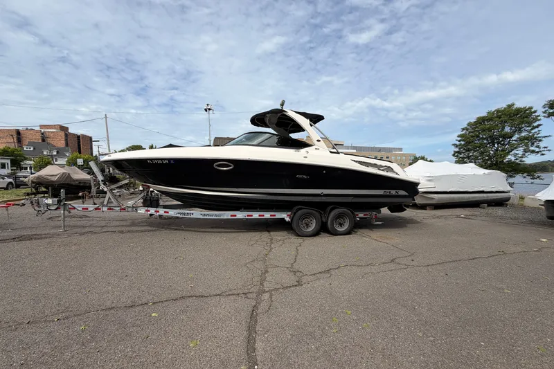 Slide: The Image of 2011 Sea Ray 300 SLX boat on trailer in a marina parking lot. - 5