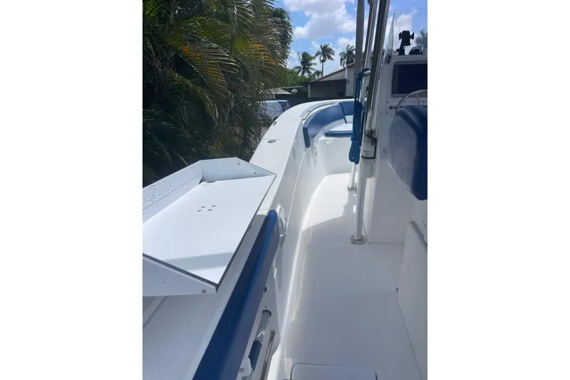 Slide: The Image of 2009 Sea Fox 288 Commander boat interior with blue seating and palm trees in background. - 16
