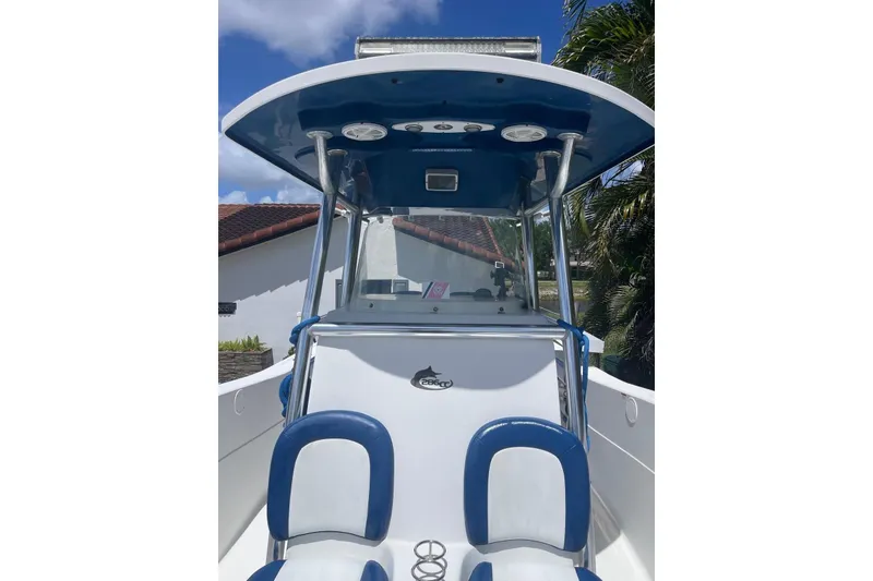 Slide: The Image of 2009 Sea Fox 288 Commander boat with blue and white seating, under a clear sky. - 20