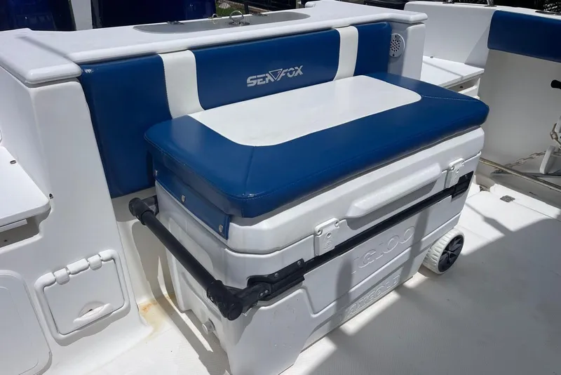 Slide: The Image of 2009 Sea Fox 288 Commander boat interior with blue and white seating and cooler storage. - 21
