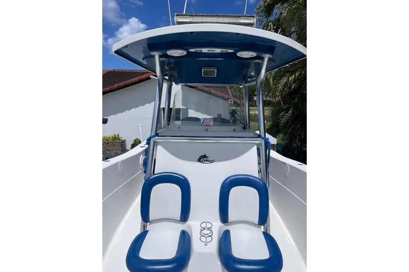 Slide: The Image of 2009 Sea Fox 288 Commander boat with blue and white seating, docked under clear skies. - 5