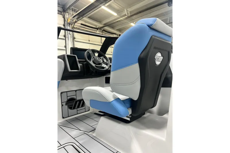 Slide: The Image of 2024 Malibu Wakesetter 24 MXZ interior with blue and gray captain's seat and steering wheel. - 12