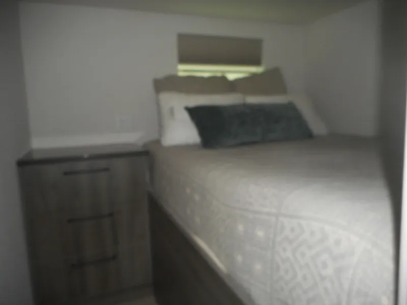 Slide: The Image of Cozy bedroom in Adonia Obsession Trip #12 RV, featuring a comfortable bed and wooden nightstand. - 13