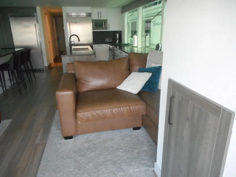 Slide: The Image of Modern living area in Adonia Obsession Trip #12, 2021, featuring leather sofa and sleek kitchen. - 24