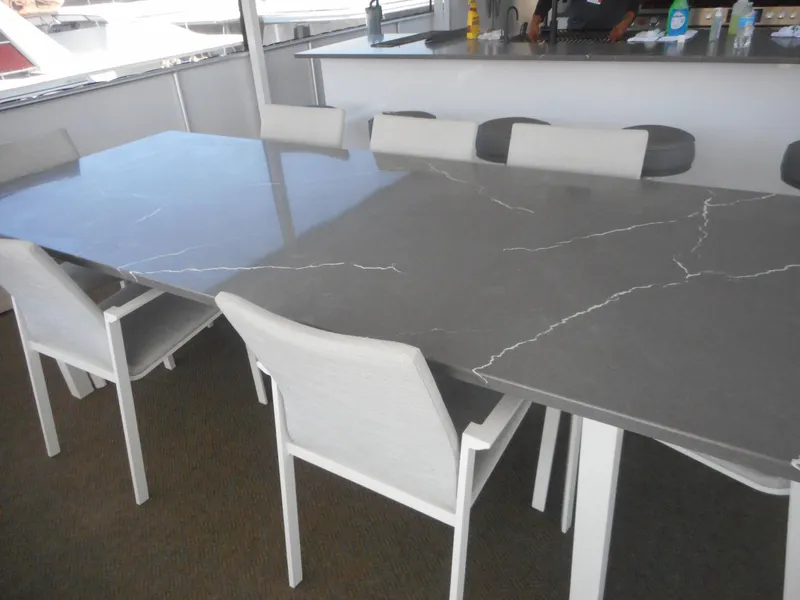 Slide: The Image of Modern dining area on Adonia Obsession Trip #12 yacht, featuring sleek gray tables and white chairs. - 35