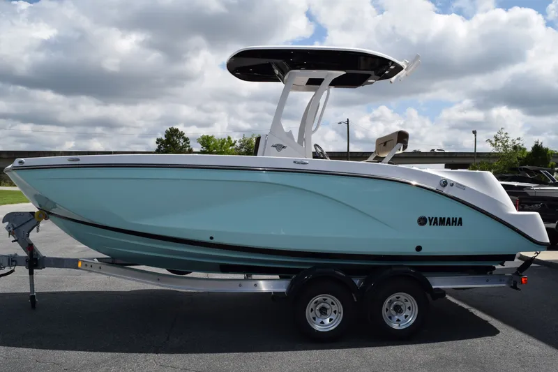 Slide: The Image of 2026 Yamaha Boats 222FSH SP E on trailer, blue hull, cloudy sky. - 22