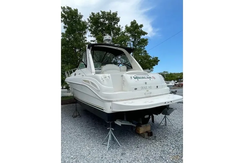 Slide: The Image of 2000 Sea Ray 340 Sundancer boat on stands, outdoor setting, clear sky. - 5