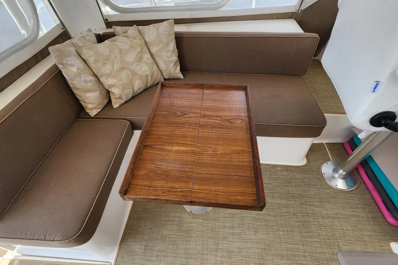Slide: The Image of Interior of 2003 Endeavour 44 TrawlerCat with brown seating and wooden table. - 12