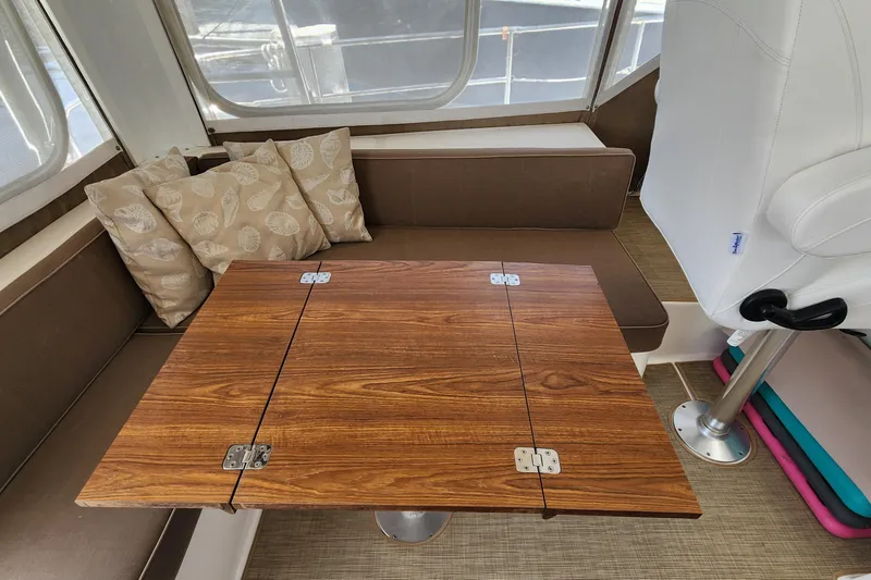 Slide: The Image of Interior of 2003 Endeavour 44 TrawlerCat with wooden table and cushioned seating. - 13